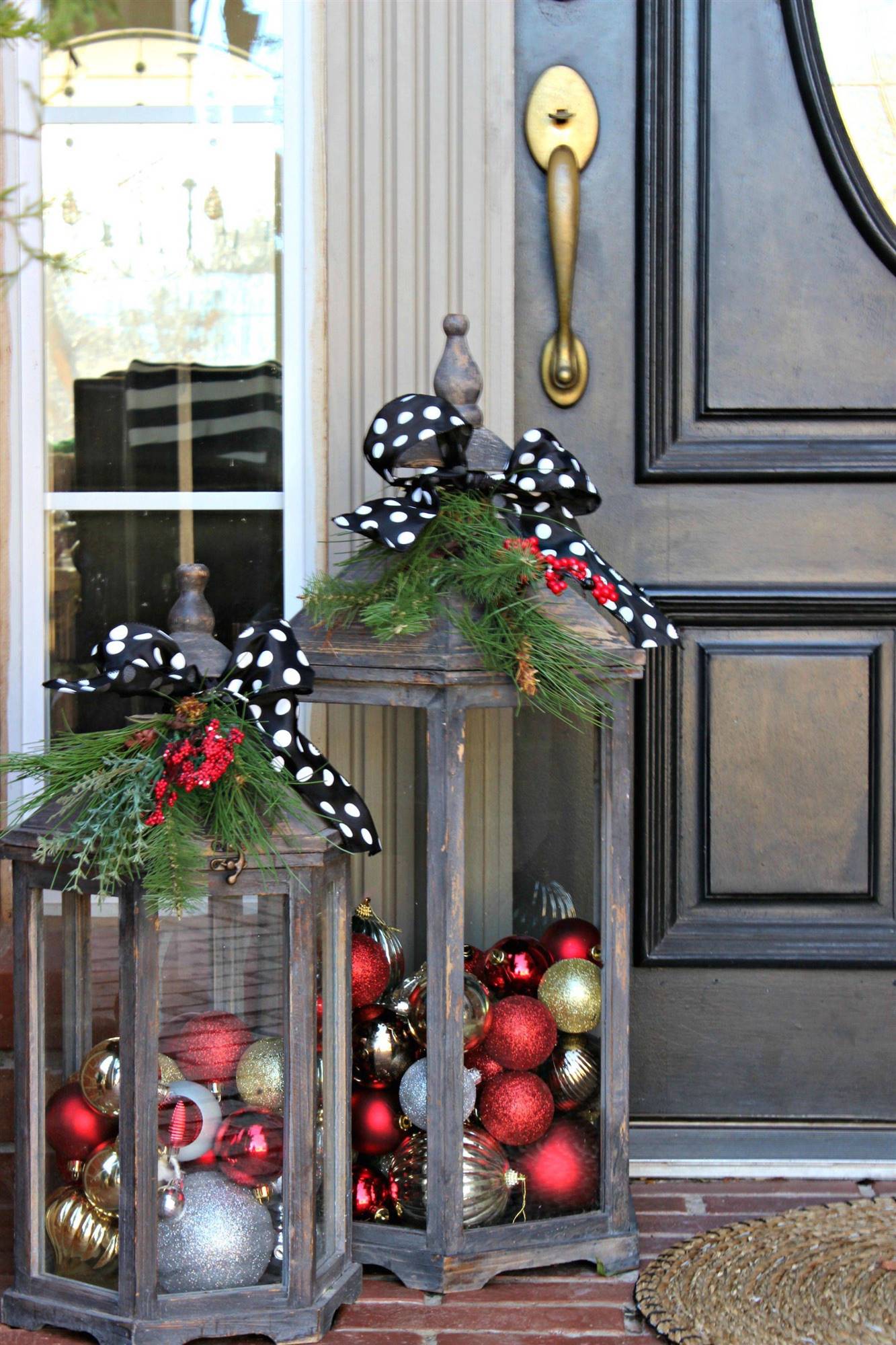 Faroles decorados con bolas de Navidad y lazos en la entrada de casa