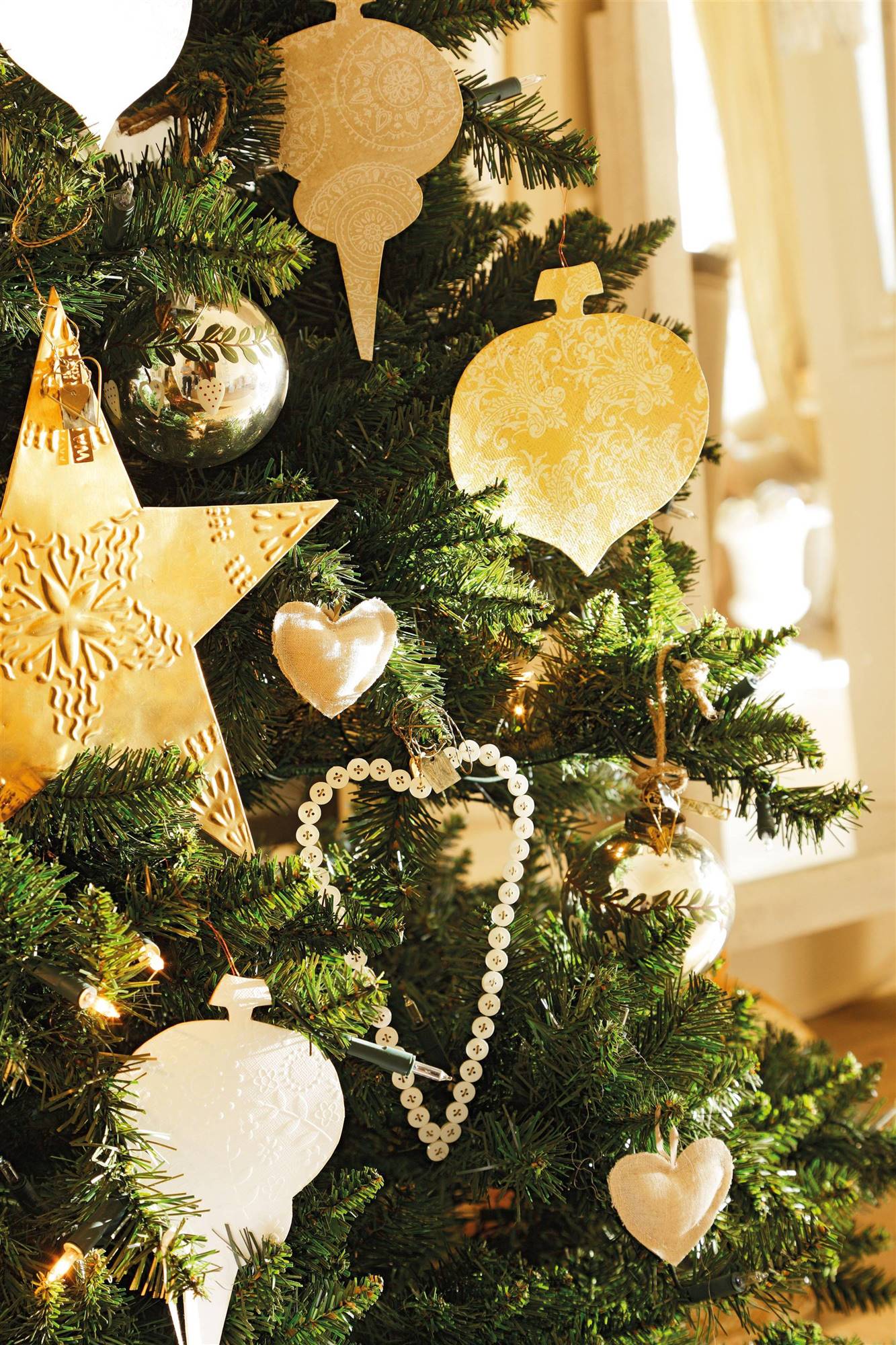 Árbol de Navidad con adornos de metal dorados. 
