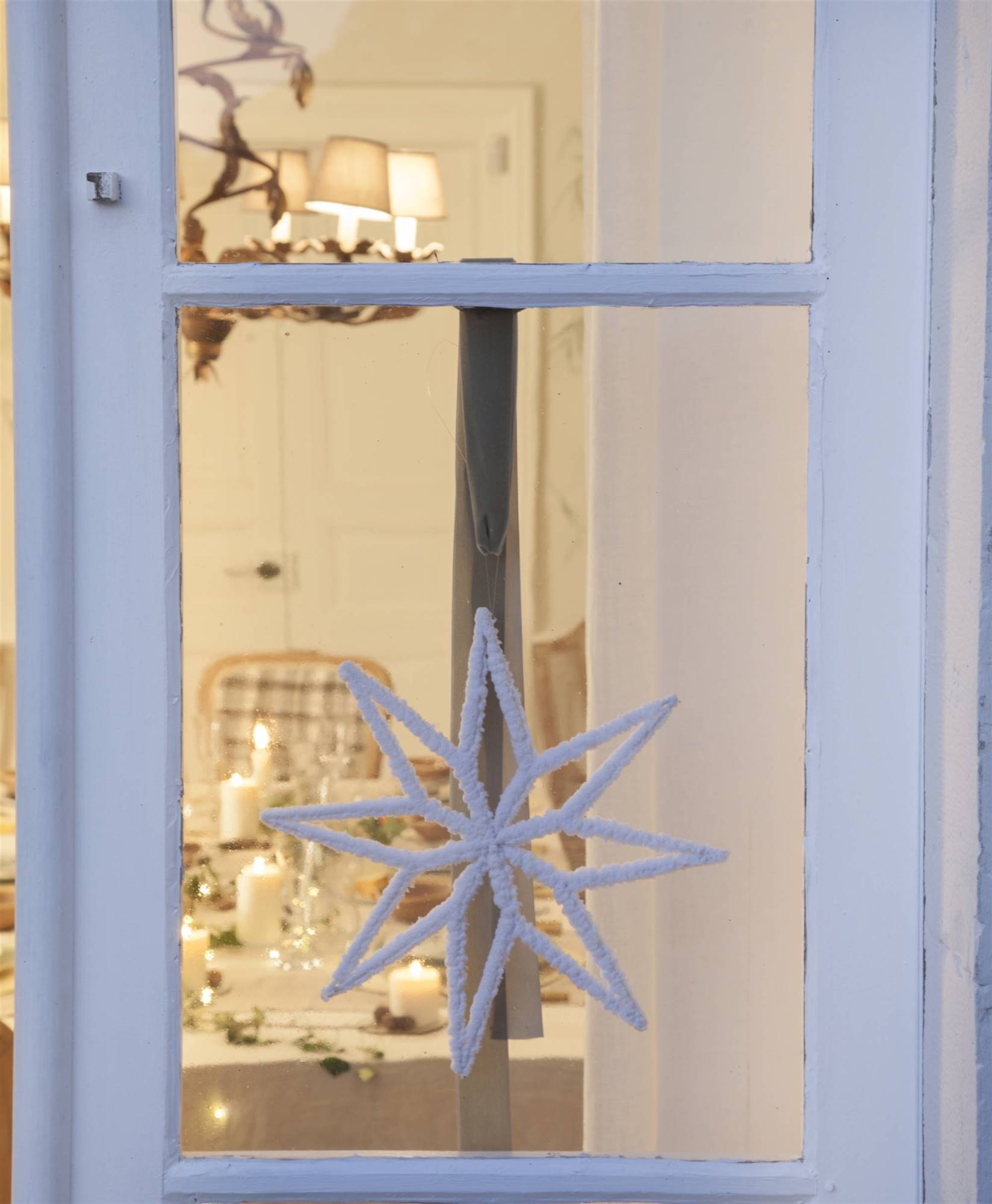 Estrella blanca navideña colgada en puerta.