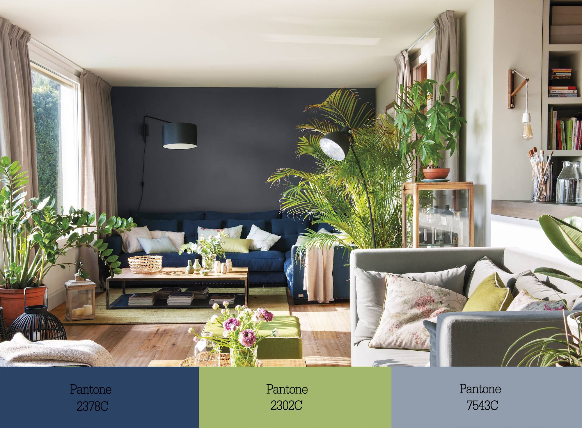 Salón con sofá azul oscuro, sofá gris y elementos verde pistacho. 