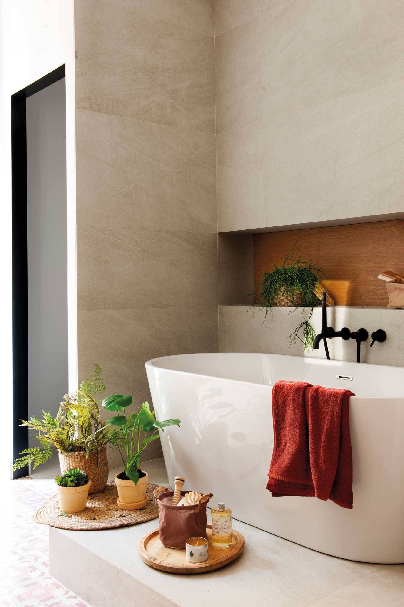 Baño moderno con bañera exenta sobre un escalón.