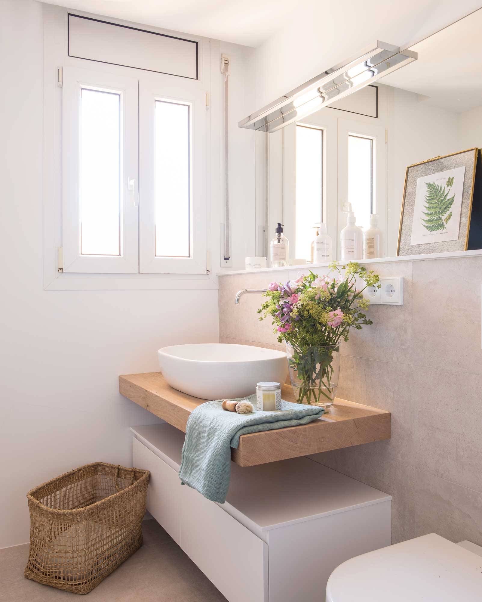 Baño moderno con mueble de lavabo en blanco y encimera de madera. 