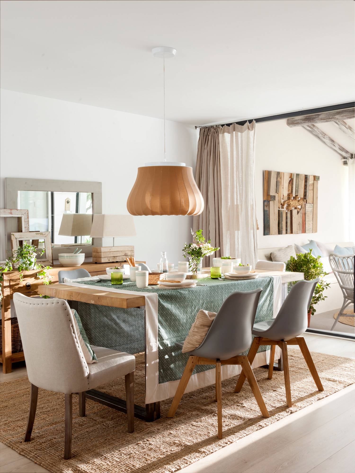 Comedor con mesa de madera y alfombra de fibras de IKEA. 