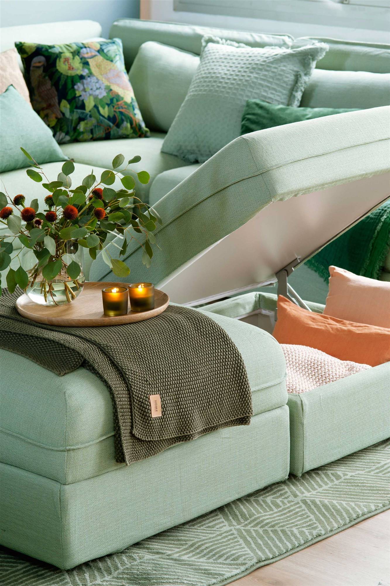 Detalle de un sofá con arcón de almacenaje que se abre mediante sistema hidráulico. 