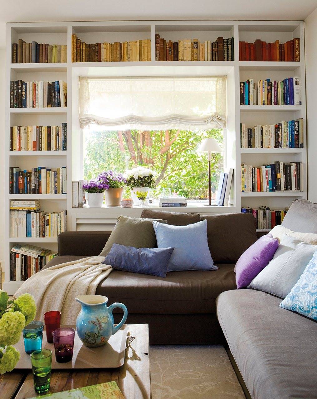Salón con una librería rodeando la ventana. 