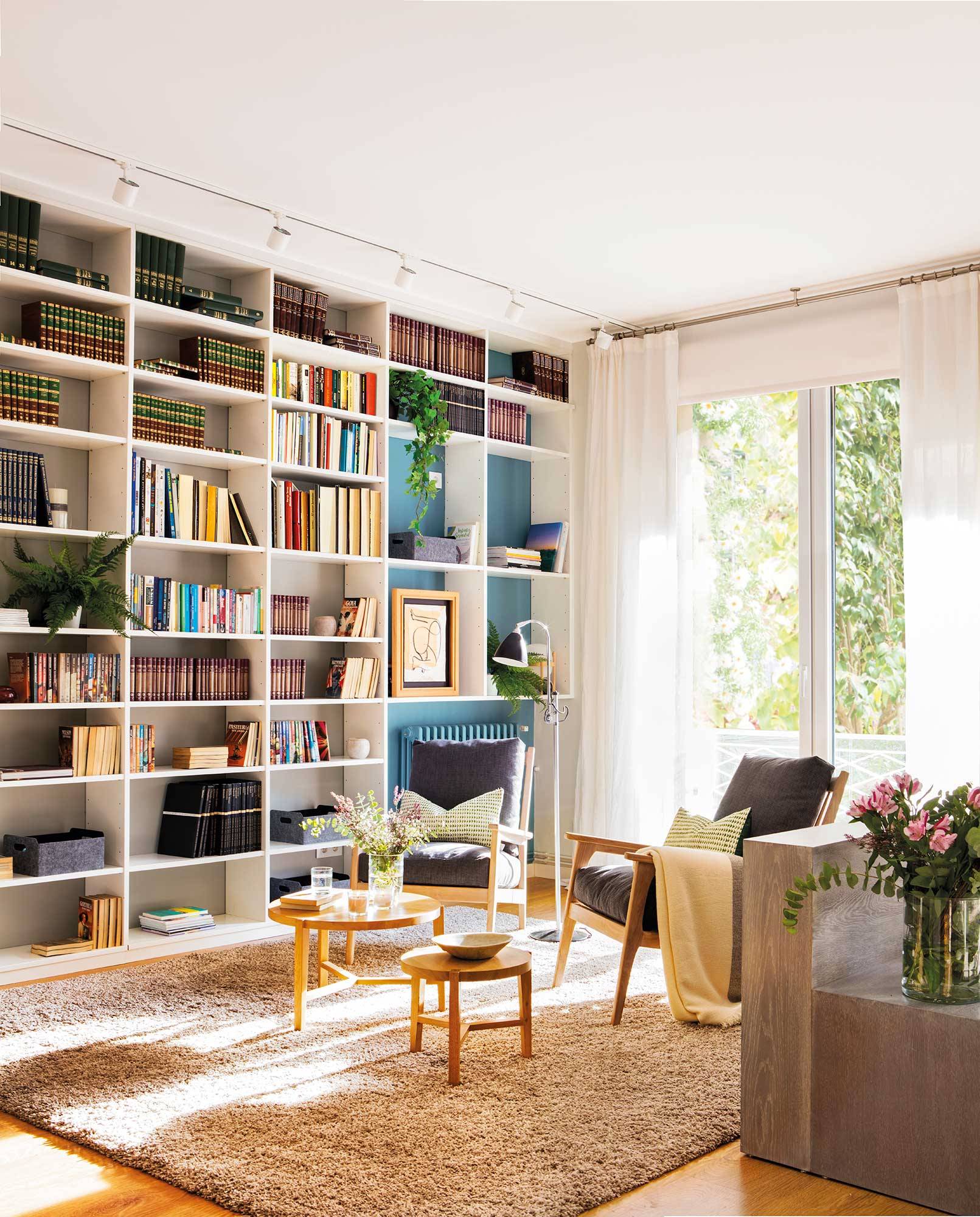 Rincón de lectura de salón con librería XL con fondo de color azul. 
