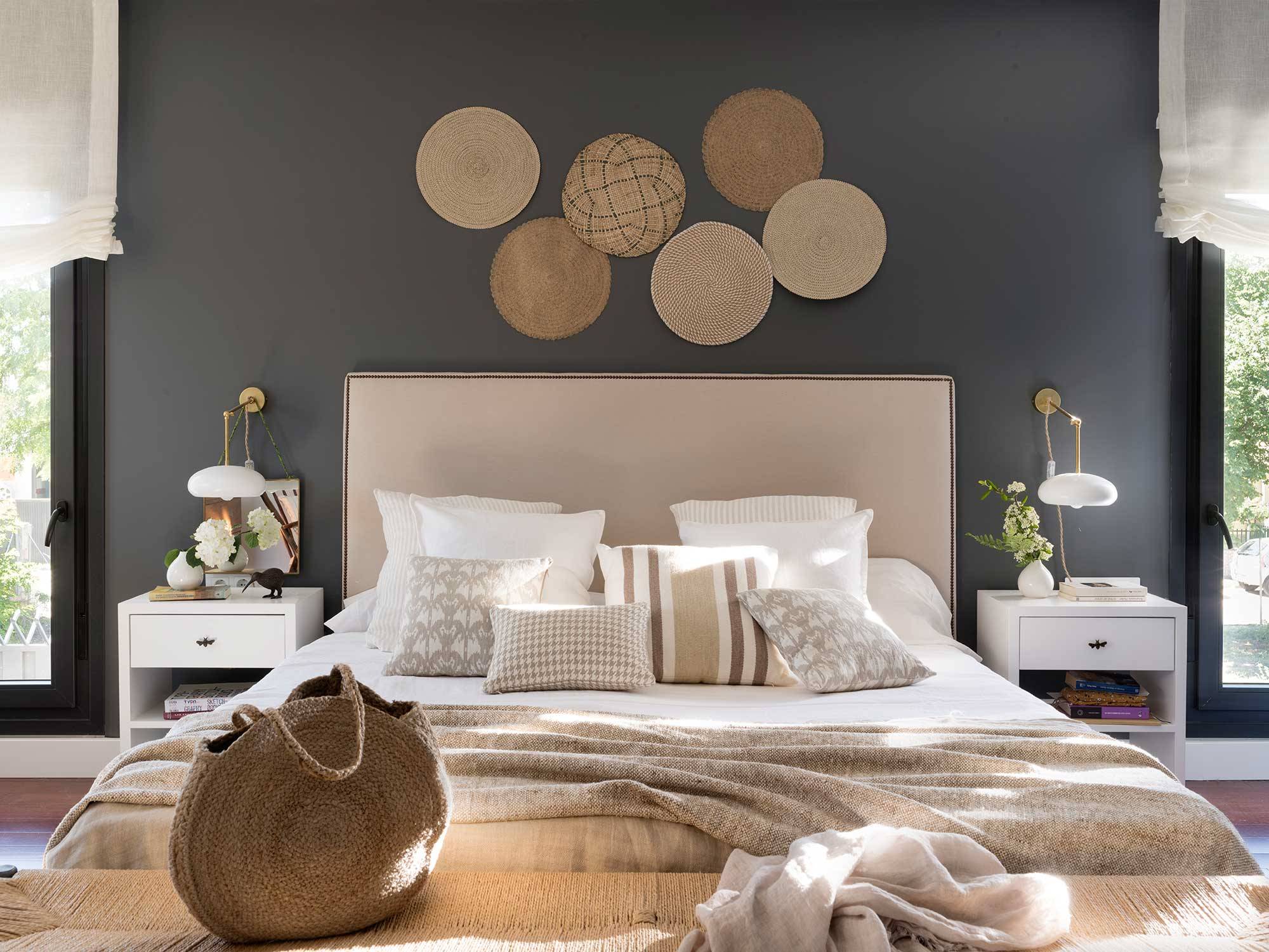 Dormitorio con pared gris oscuro y composición decorativa de individuales colgados_00527500 O