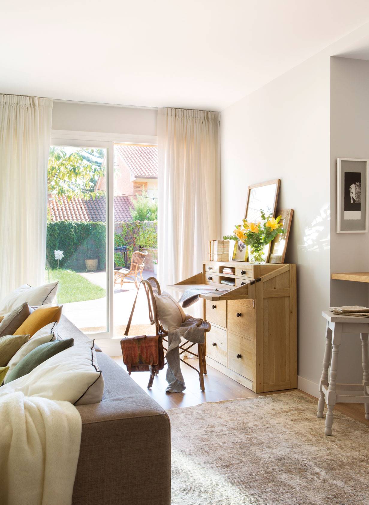 Rincon de salon con secreter y silla a modo de zona de trabajo, con alfombra, cuadrod, flores y ventana con cortinas-469259