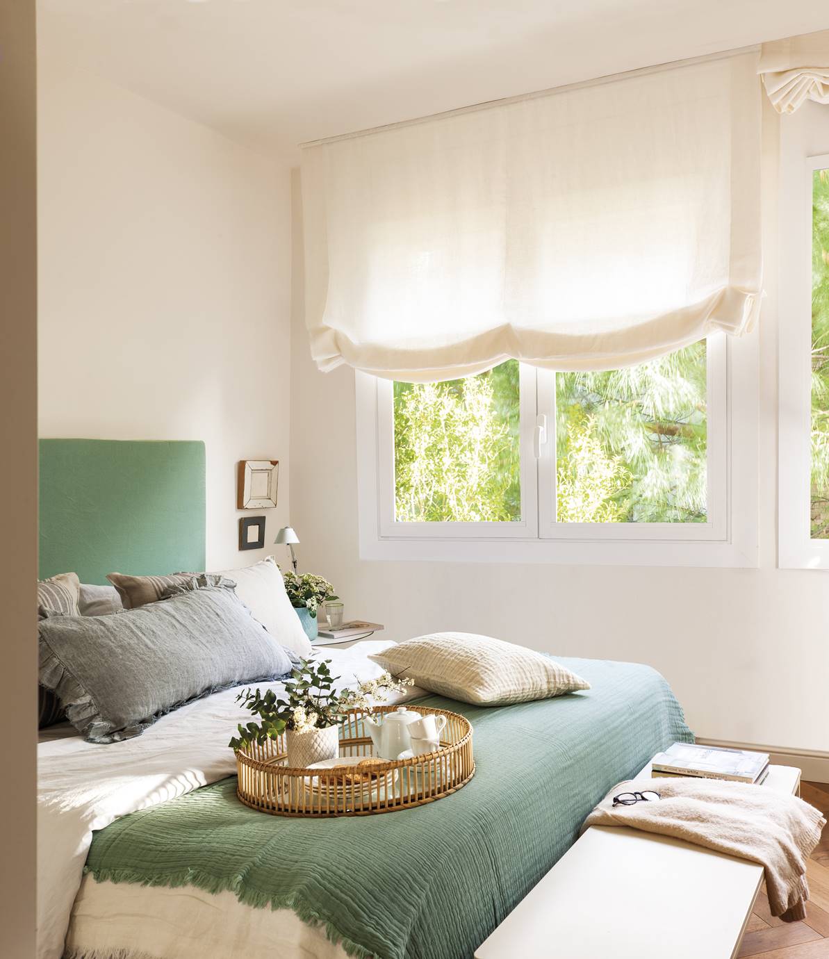 Dormitorio con cabecero tapizado en verde agua