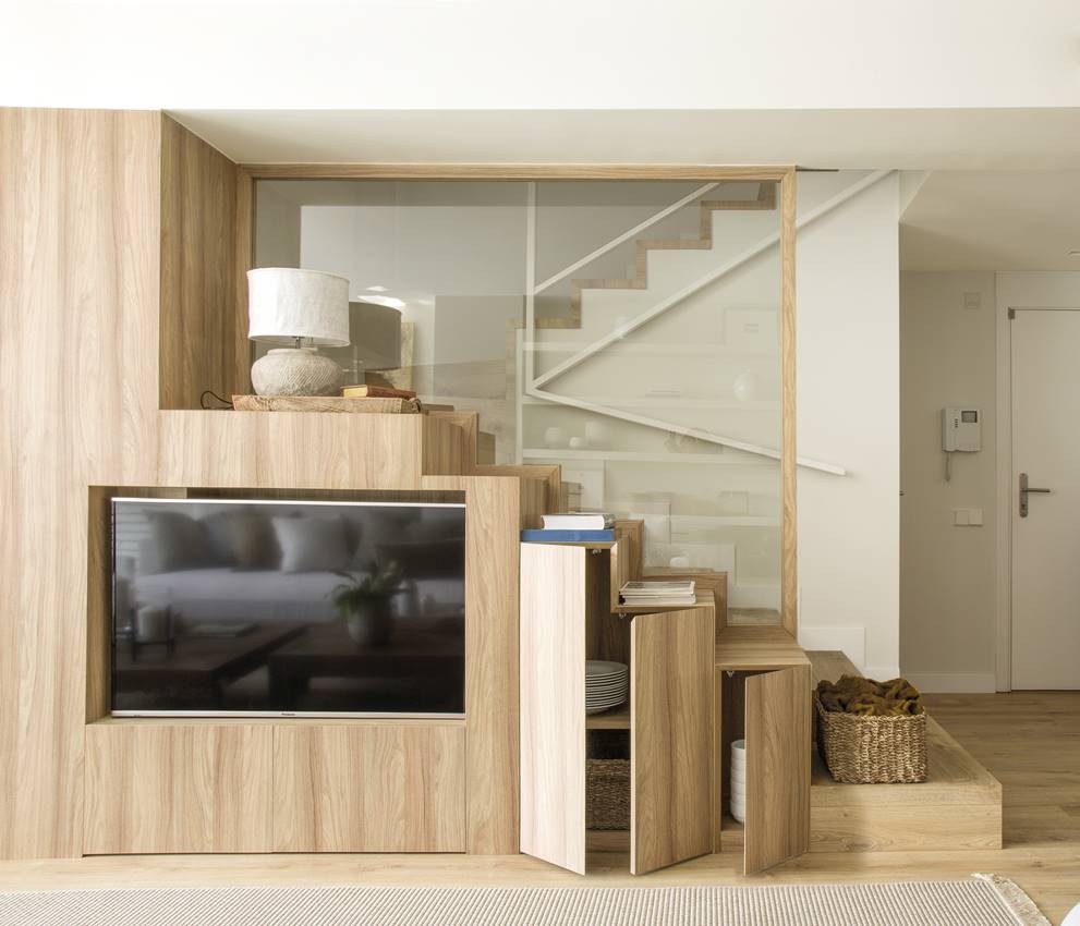 Escaleras de madera diseñadas con almacenaje y mueble para la televisión. 