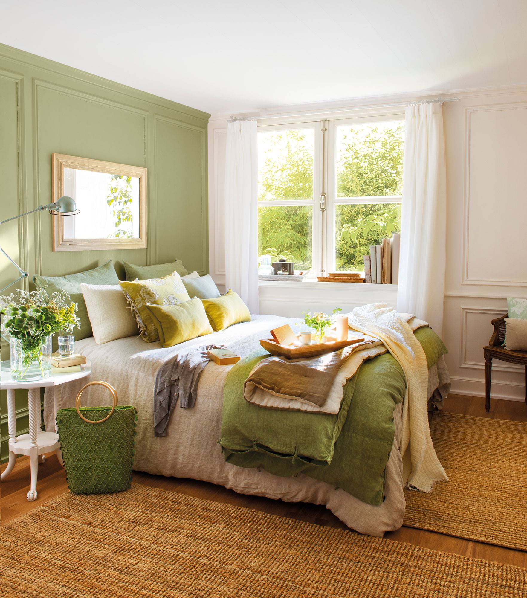 Dormitorio con pared del cabecero pintada en verde con molduras