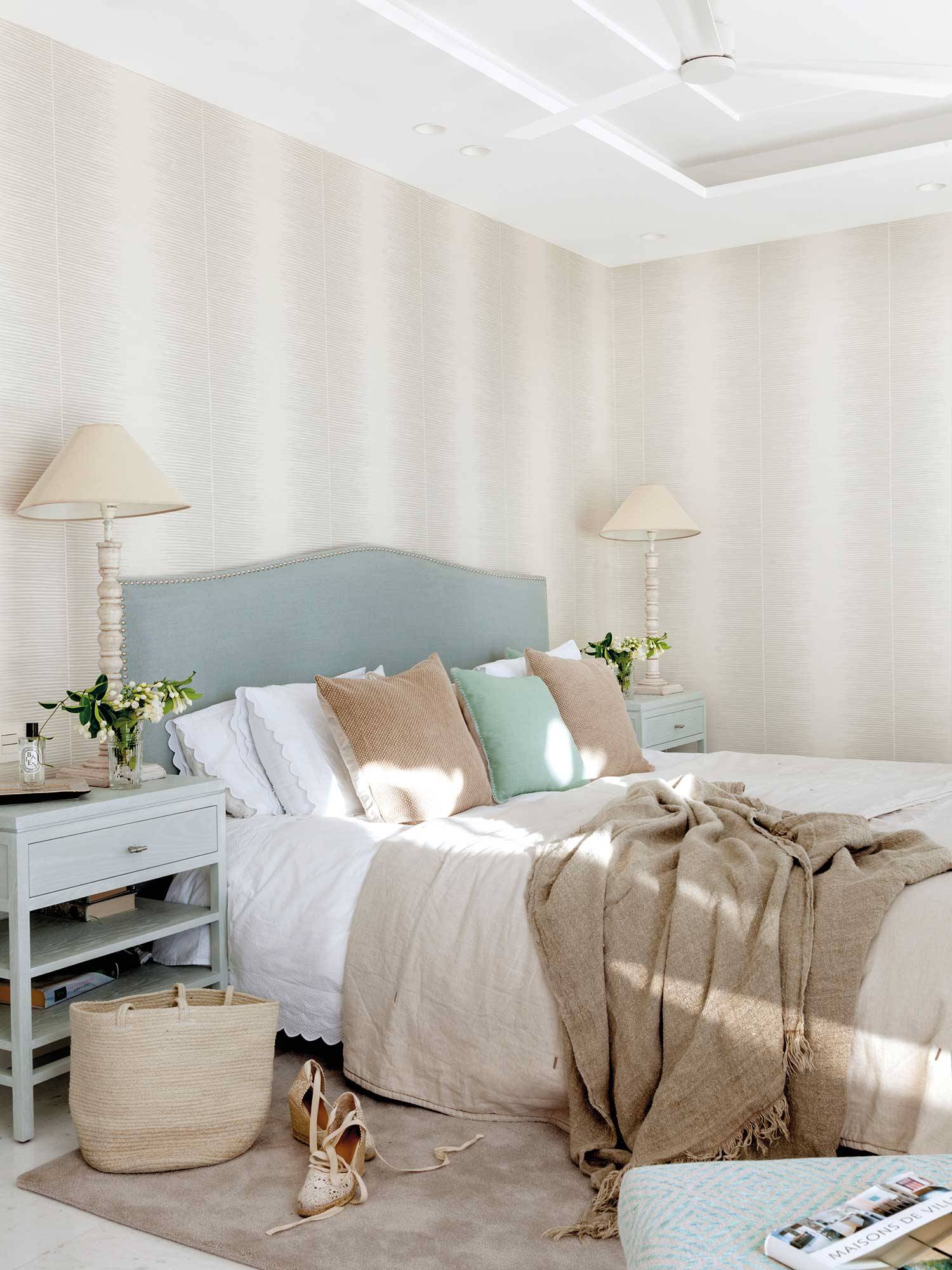 Dormitorio con papel pintado de franjas difuminadas.