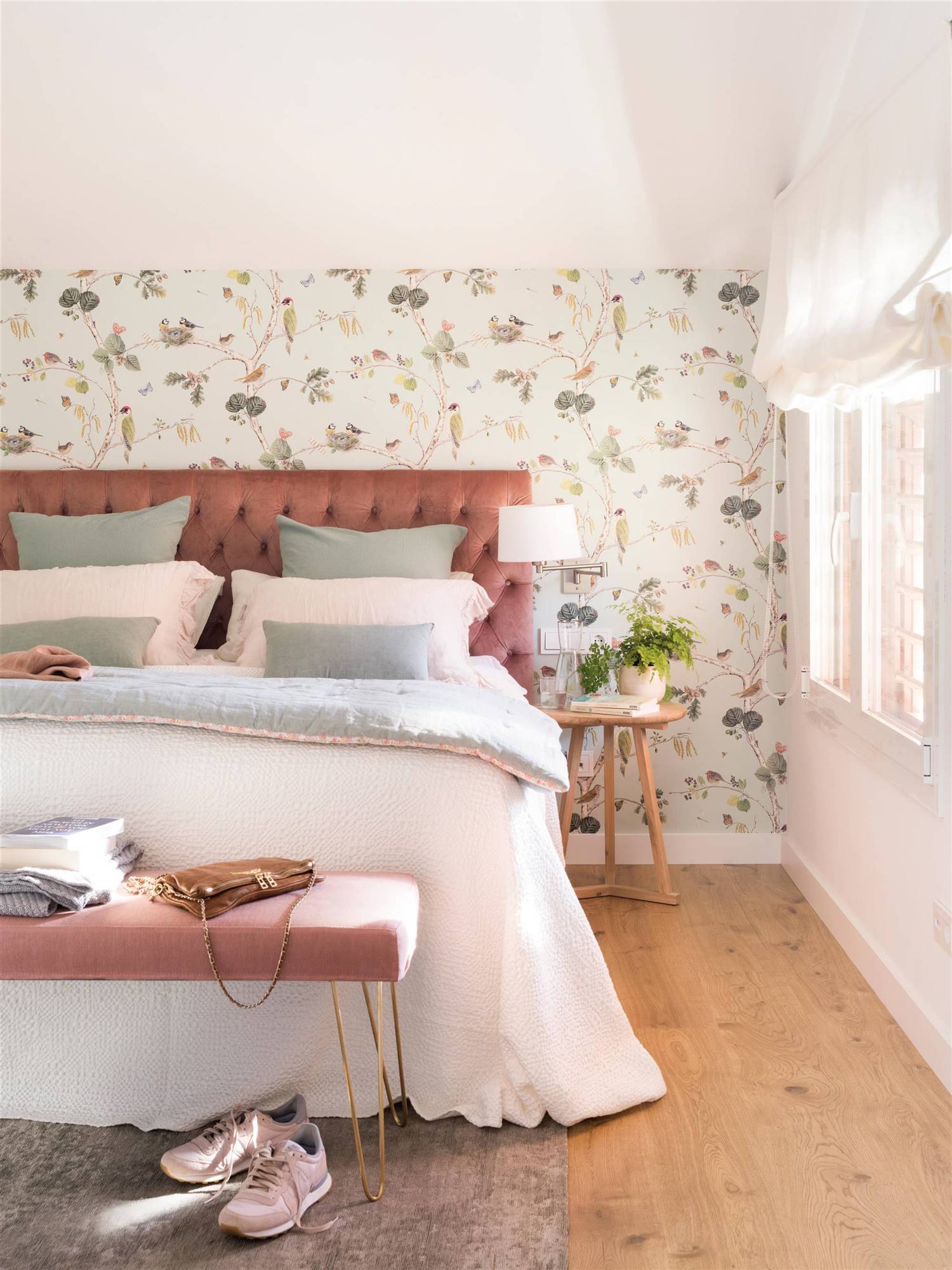Dormitorio nórdico con papel pintado y cabecero rosa en capitoné. 