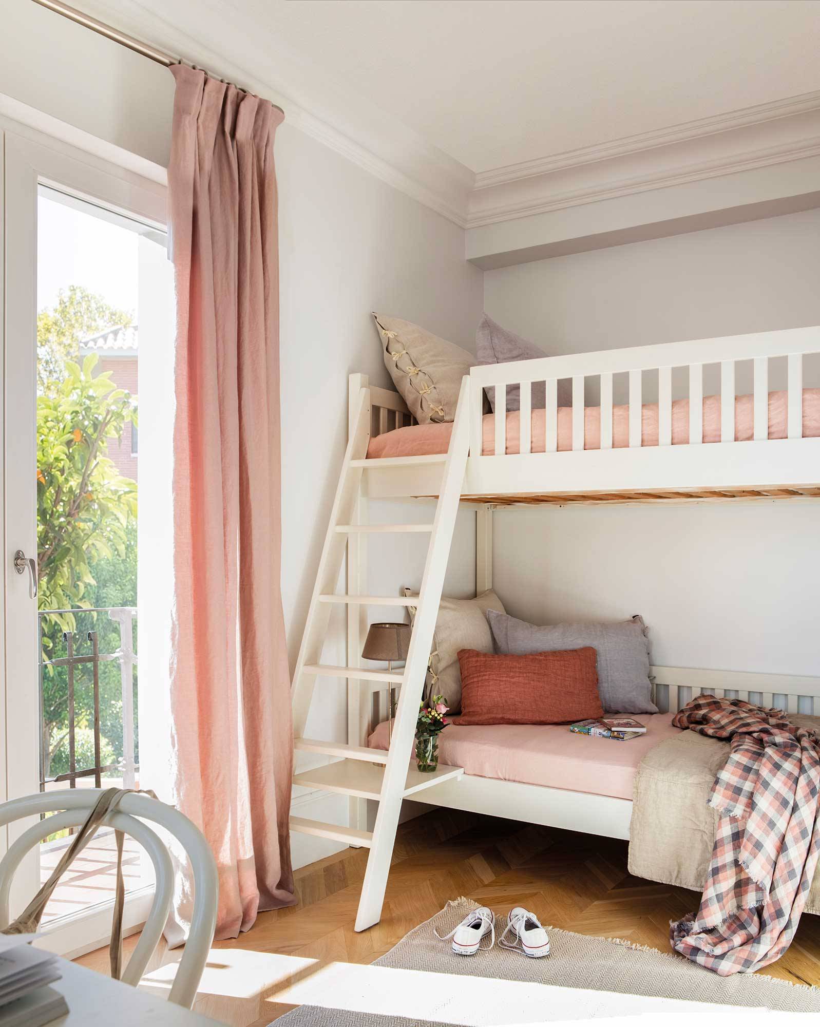 Habitación infantil con litera blanca y ropa de cama rosa.