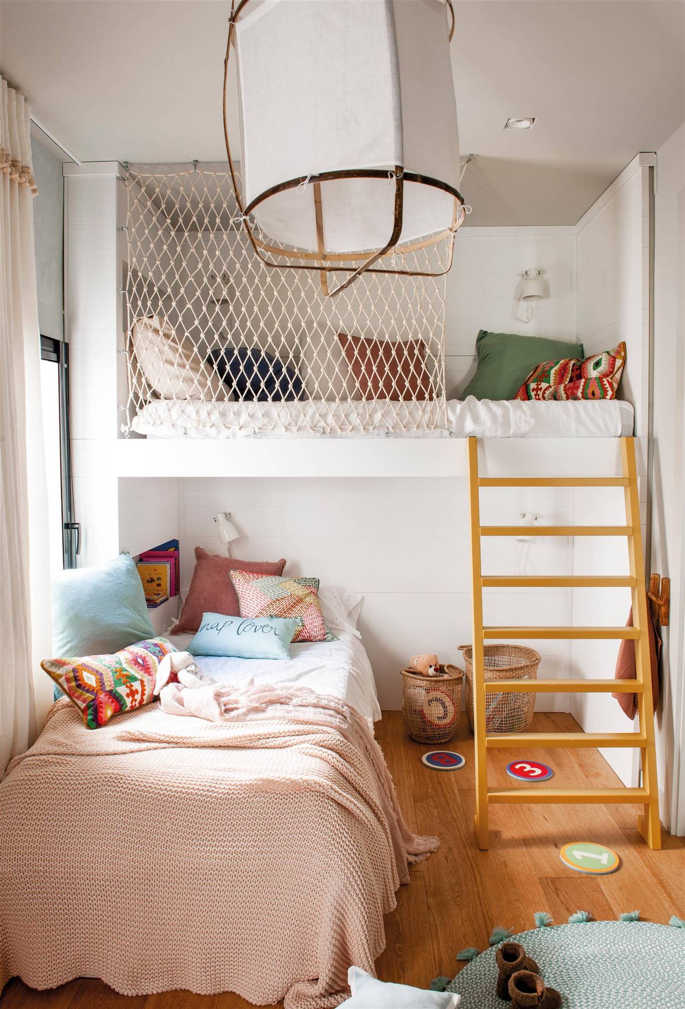 Dormitorio infantil con litera, escalera de madera y red anticaídas.
