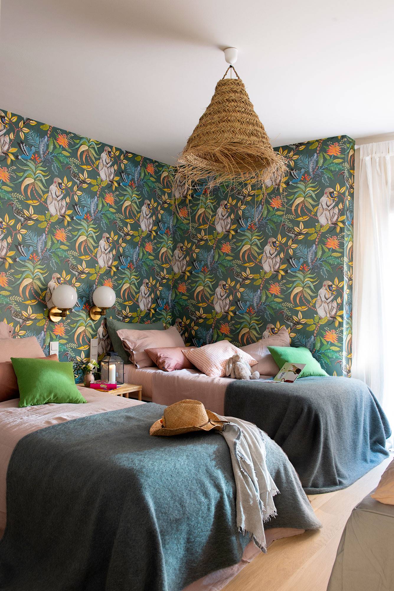 Dormitorio infantil con revestimiento de papel pintado y lámpara de techo de fibra vegetal. 