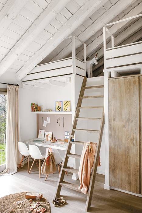 Dormitorio infantil con cama elevada con escalera de madera y escritorio debajo. 