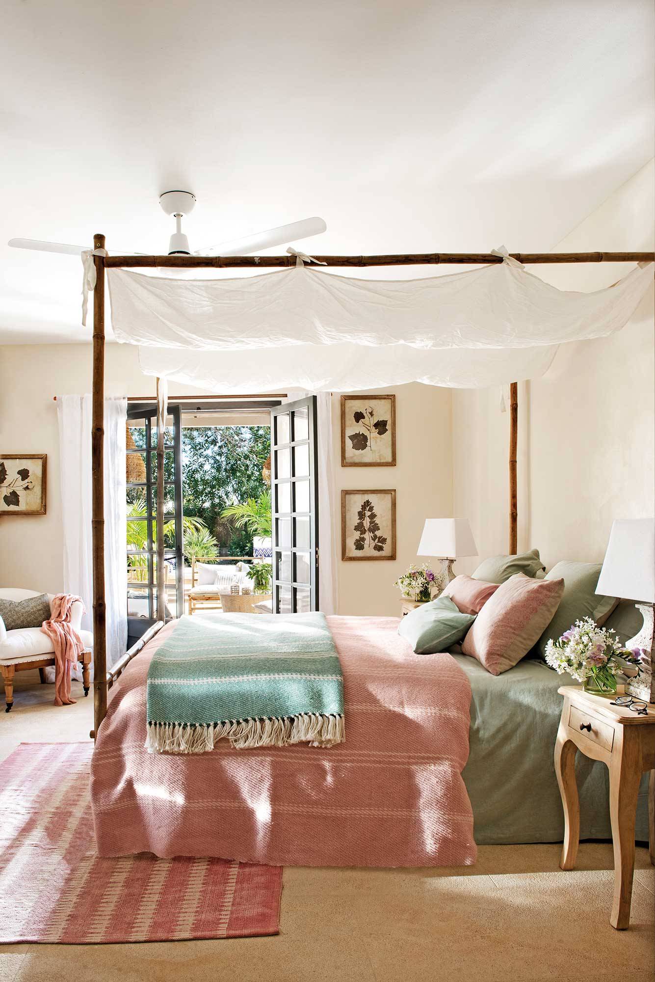 Dormitorio con cama con dosel y ropa de cama verde y rosa. 