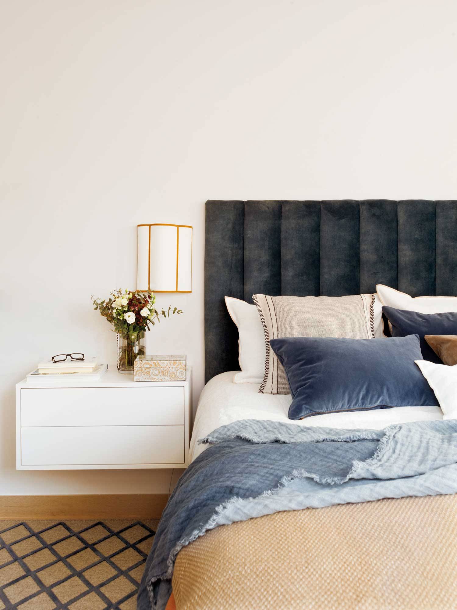 Dormitorio con cabecero tapizado en terciopelo azul oscuro y mesilla volada blanca 00521442