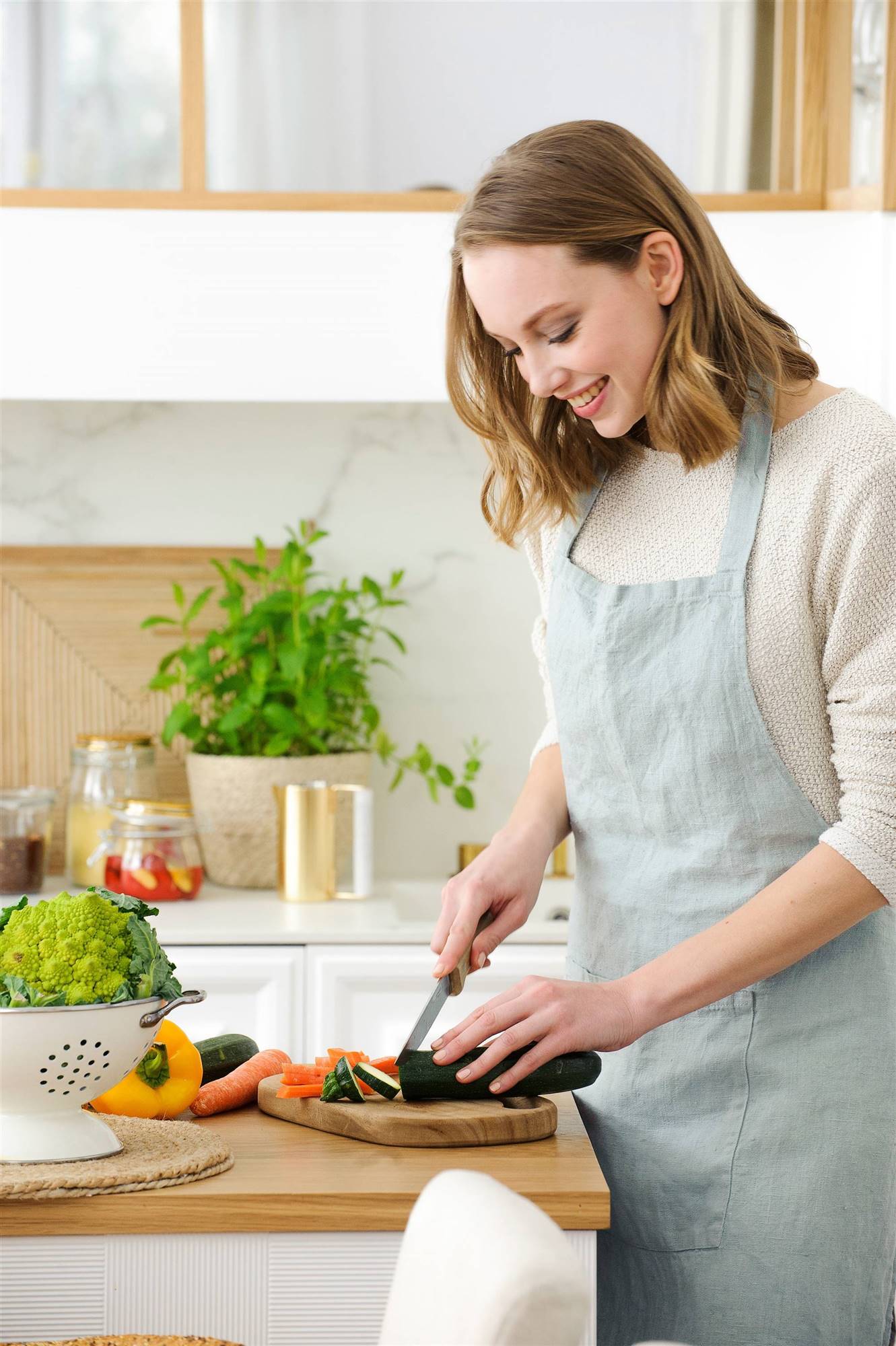 Mujer en una cocina cortando verdura 00476193_O