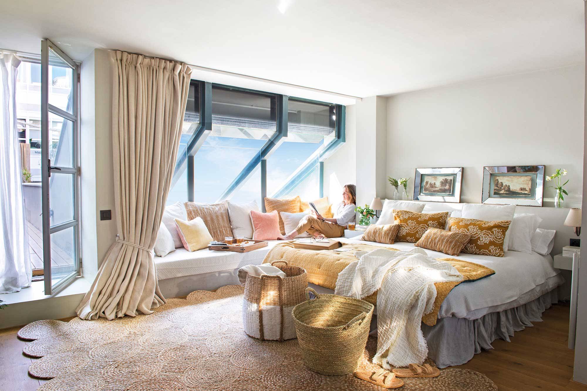 Dormitorio moderno con gran ventanal y banco a modo de chill out. 