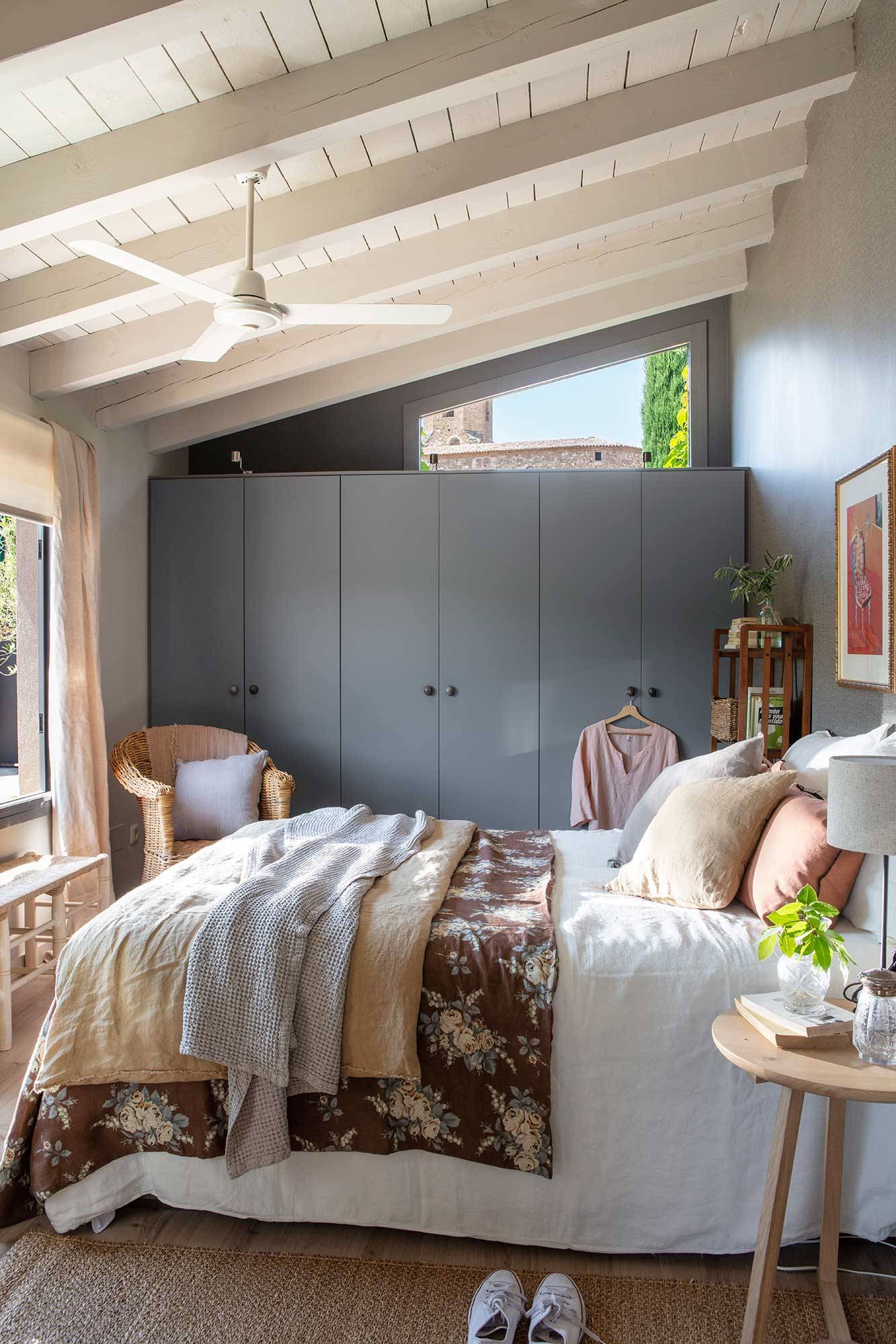 Dormitorio y abuhardillado moderno con armarios grises. 