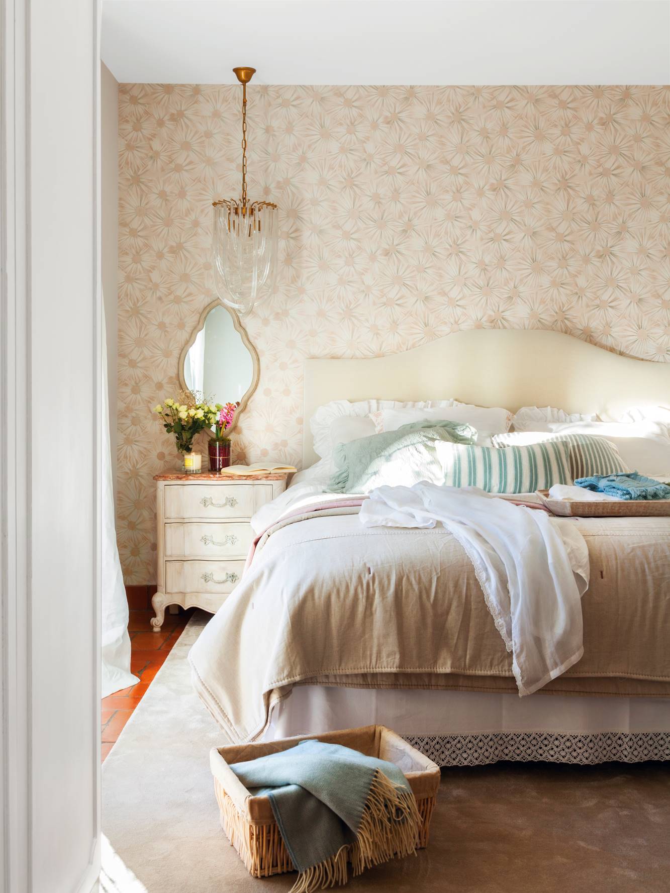Dormitorio con papel pintado de flores en el cabecero. 