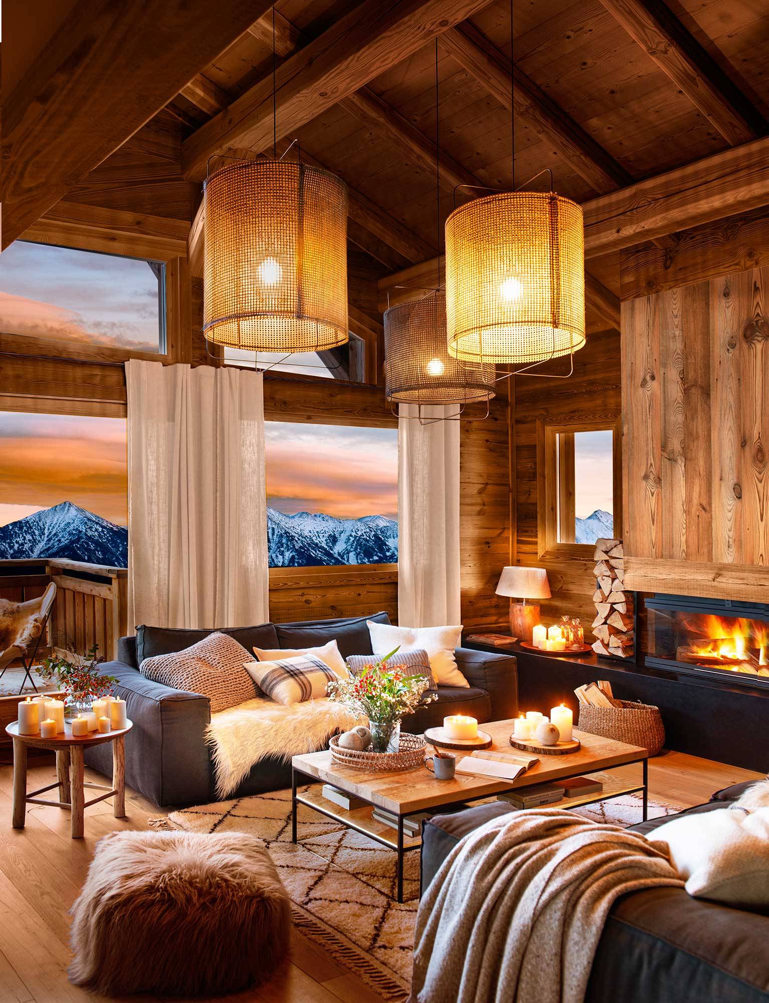 Salón de casa de montaña con paredes vestidas de madera y grandes lámparas modernas y vistas a las montañas. 