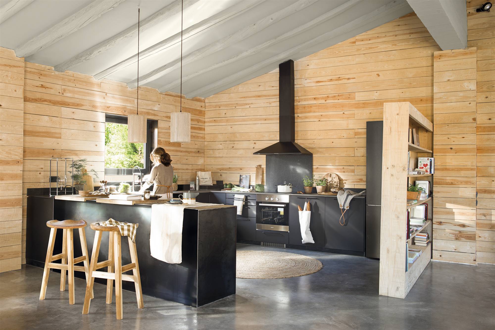 Cocina con paredes de madera y muebles negros