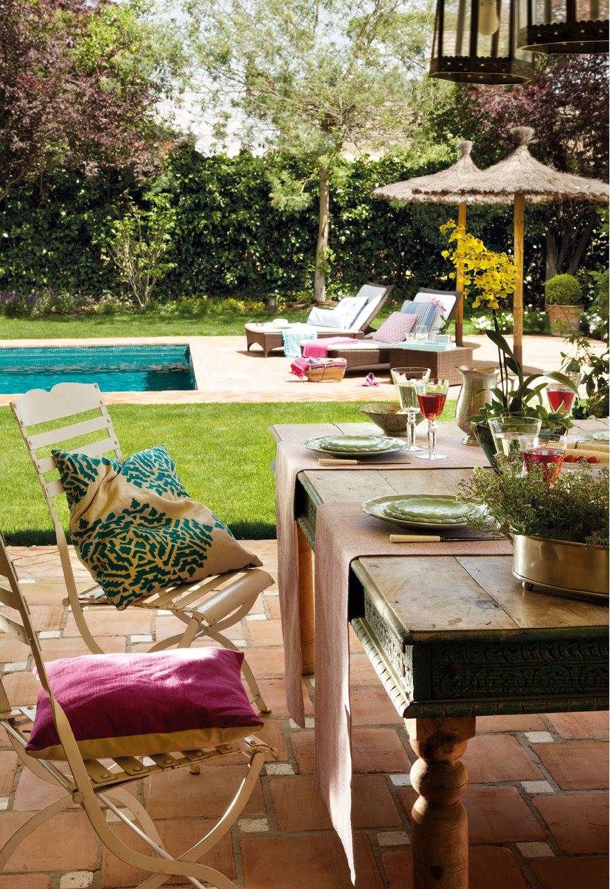 silla y mesa en un jardín con piscina