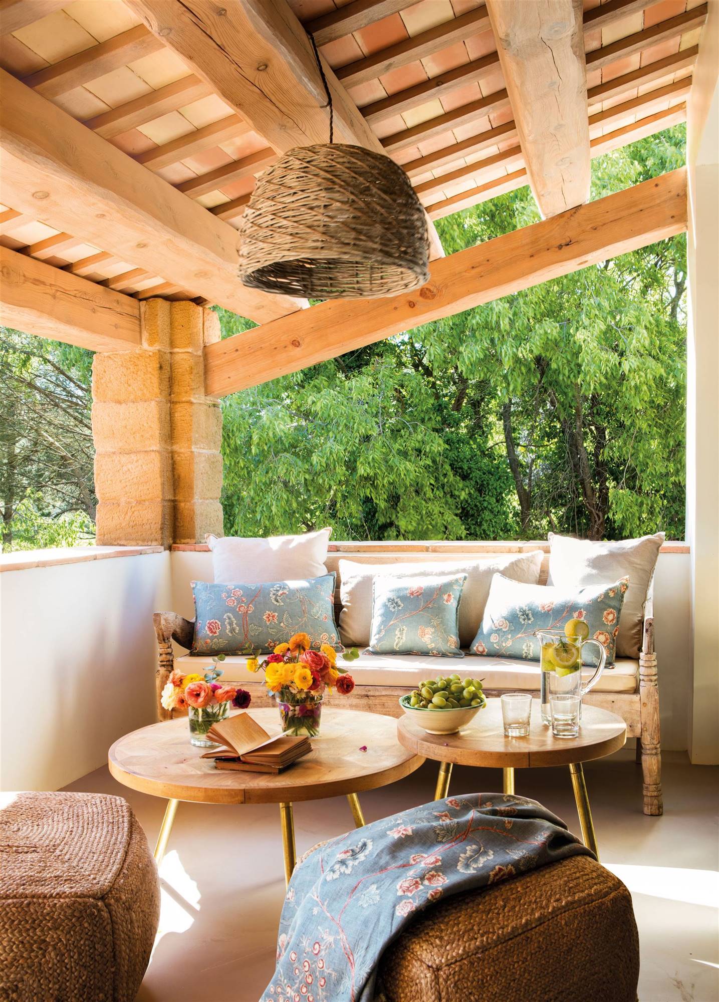 Terraza pequeña con muebles de madera y puffs de fibra natural. 