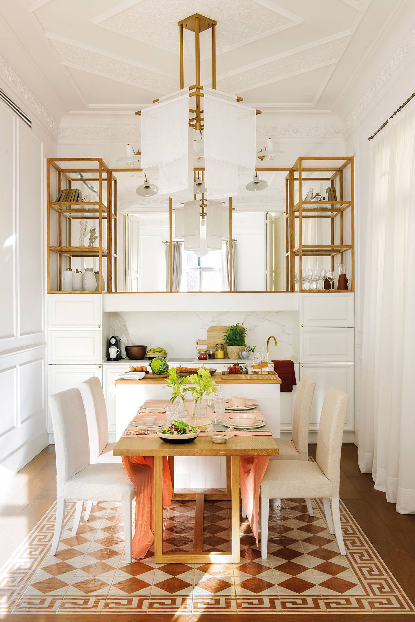 Cocina de diseño en blanco con mini isla, estantes elevados con espejos y comedor elegante con baldosas. 