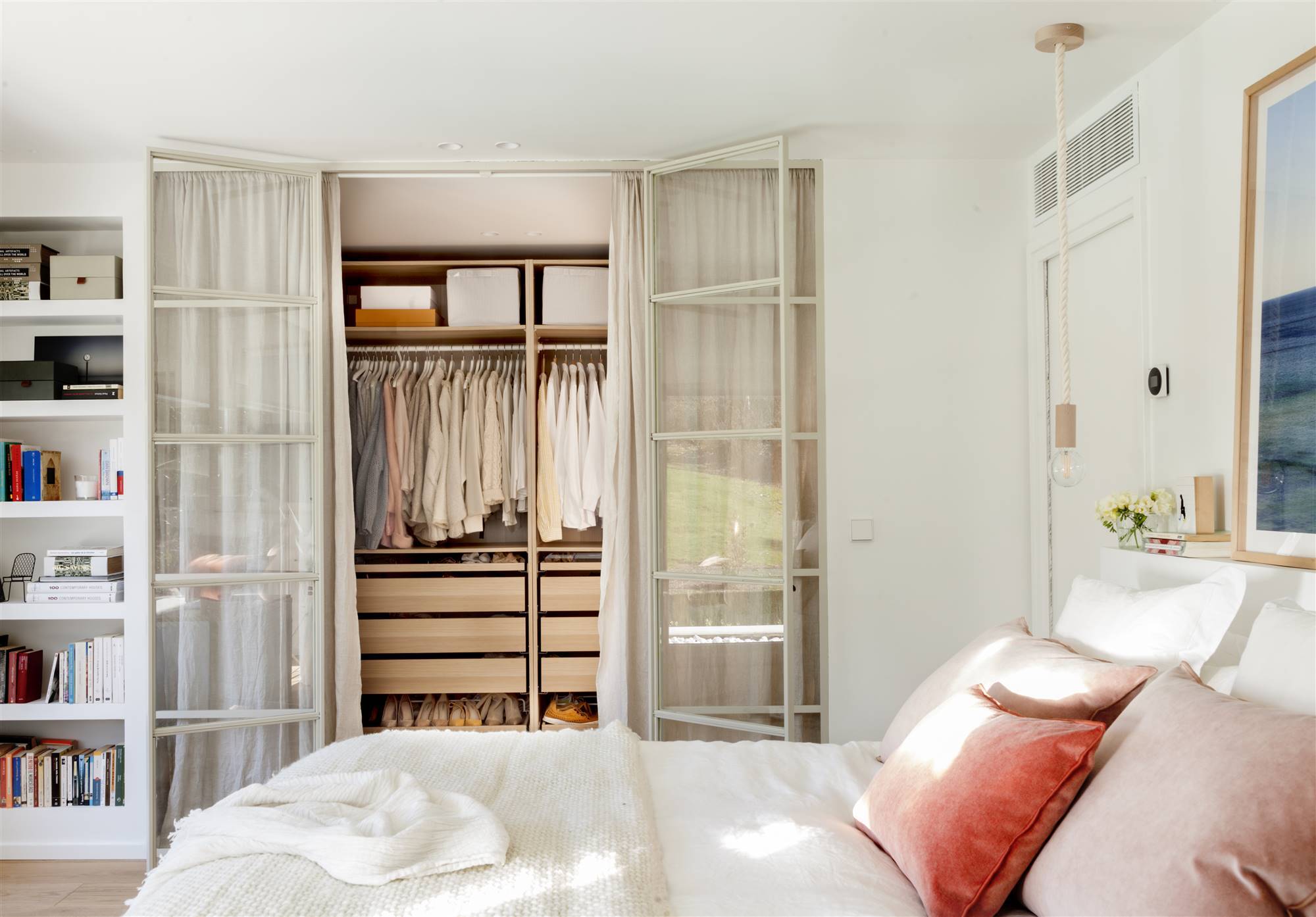 Dormitorio con vestidor tipo closet cerrado con puertas metálicas acristaladas y enteladas. 
