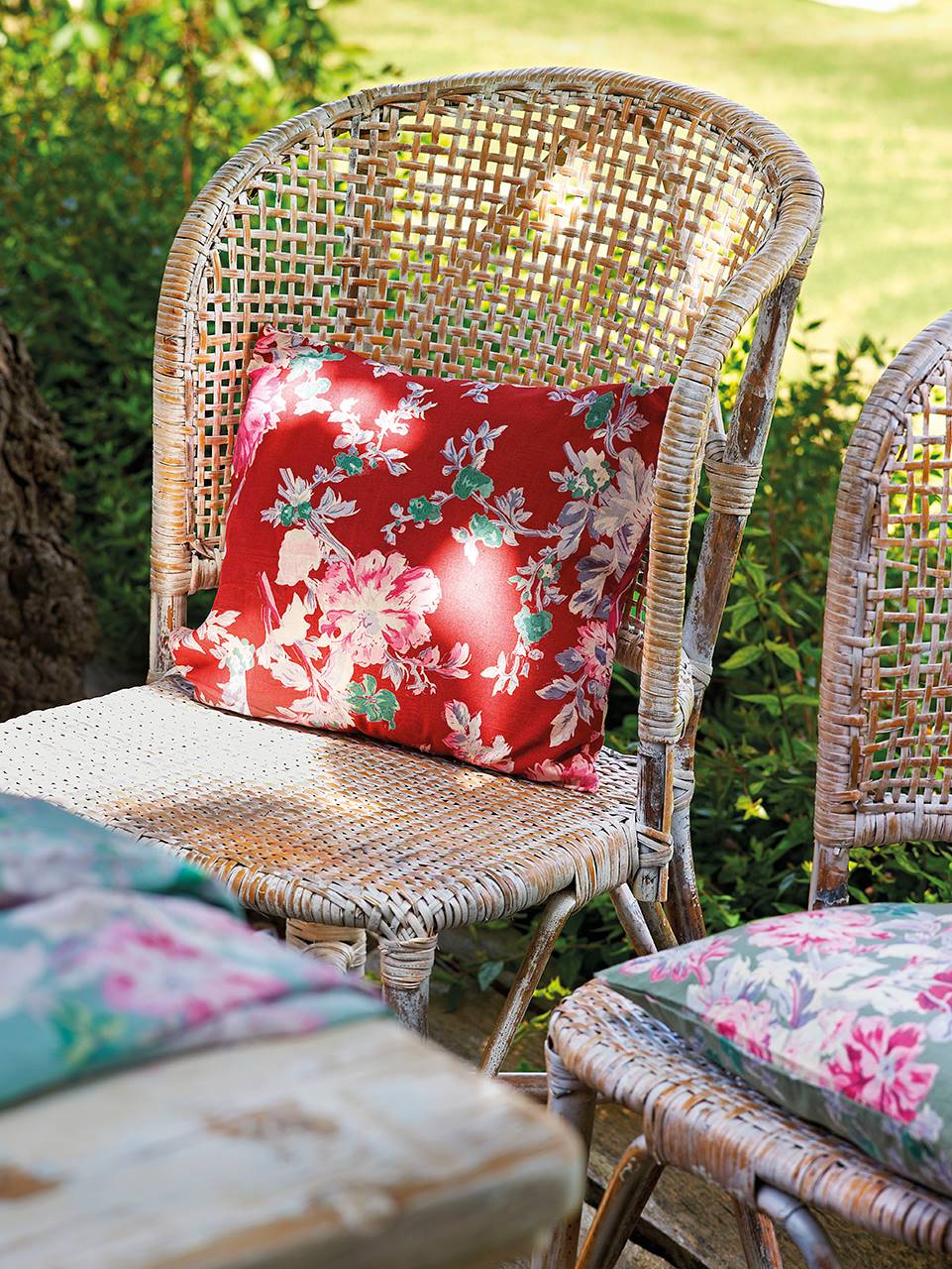 Detalle de cojines con estampado floral sobre una silla