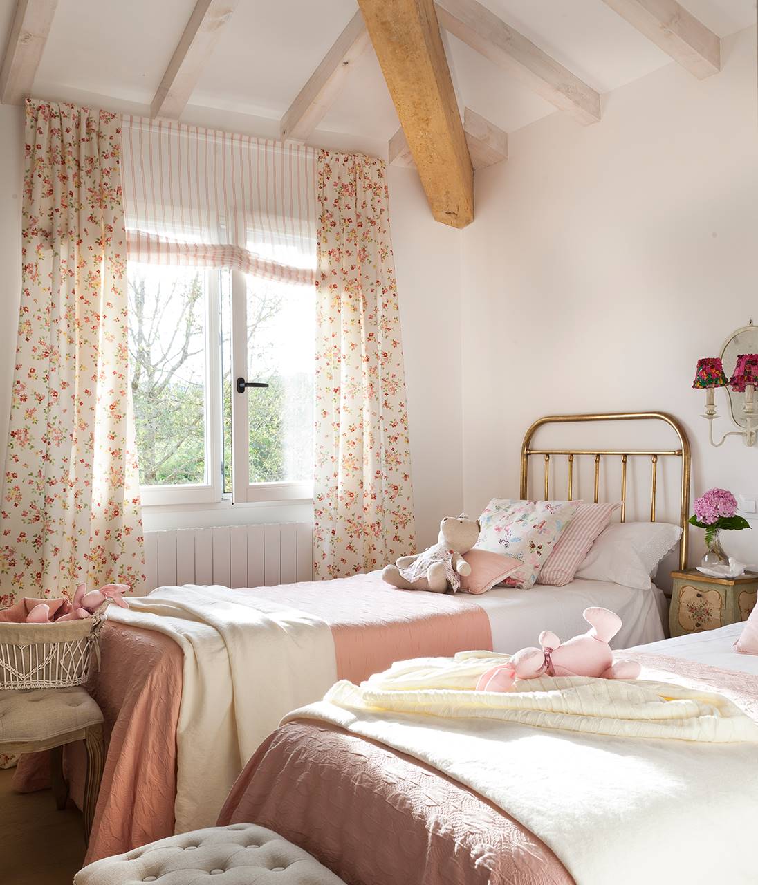 Dormitorio infantil con cabecero de metal y cortinas con estampado floral