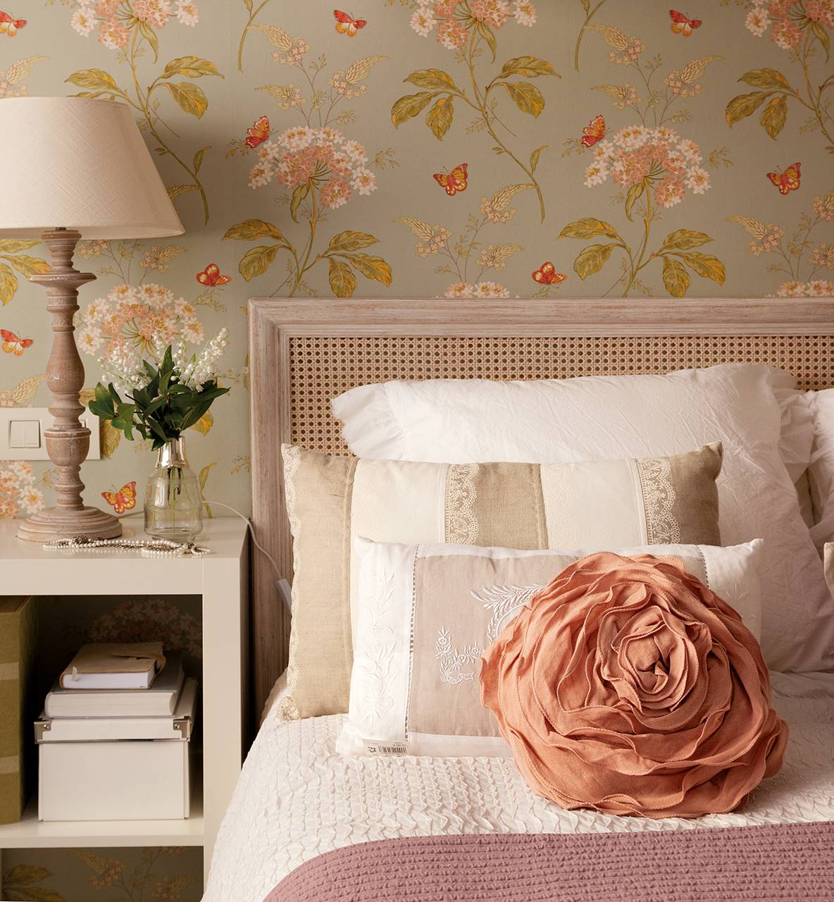 Dormitorio con cabecero de rejilla y papel de pared con motivos florales