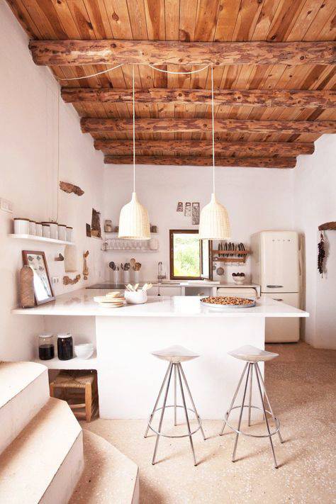 Cocina con suelo de terrazo, techo de madera natural con vigas, lámparas de techo y paredes y muebles blancos_Pinterest