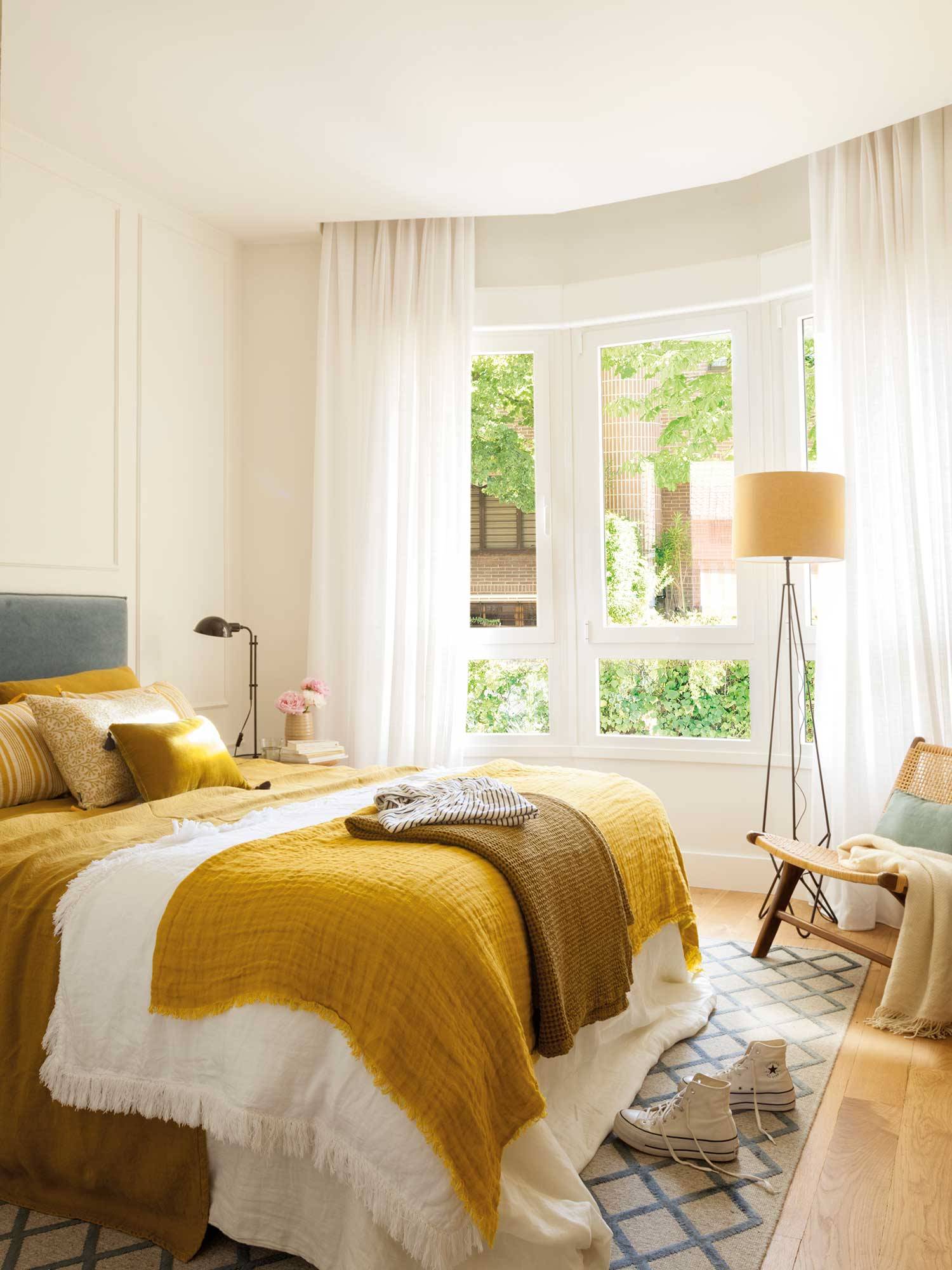 Dormitorio con pared con molduras y toques de amarillo y gris 00528735