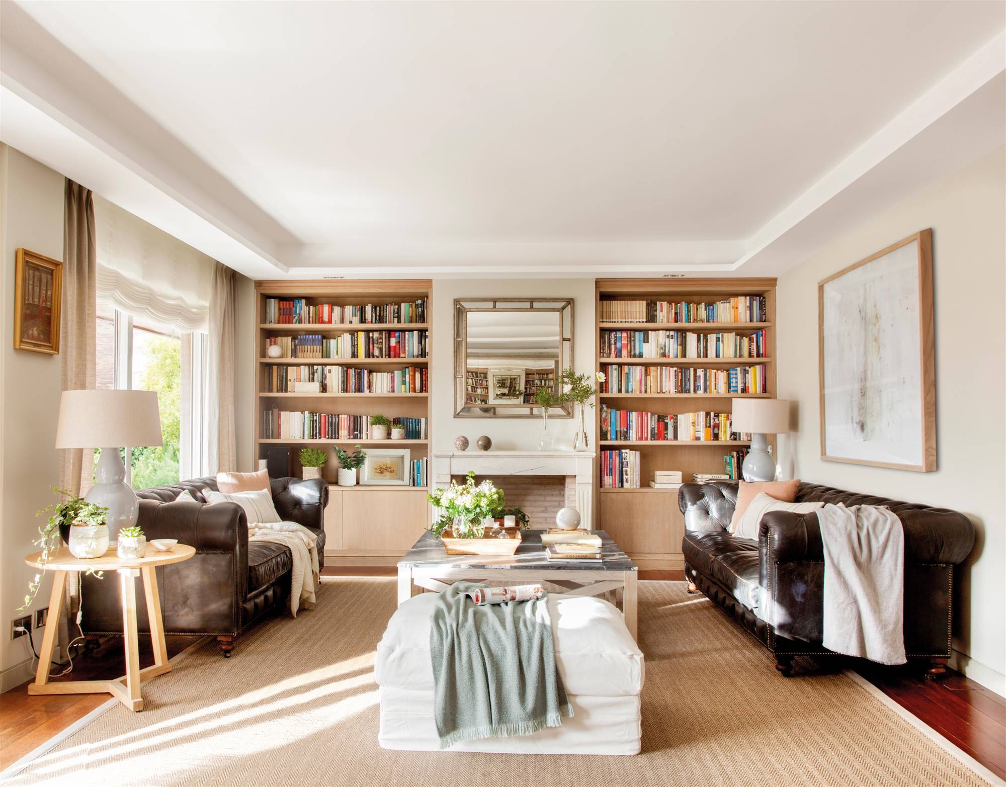 Salón de estilo clásico con librería simétrica dos sofás tipo Chester de piel 00505509