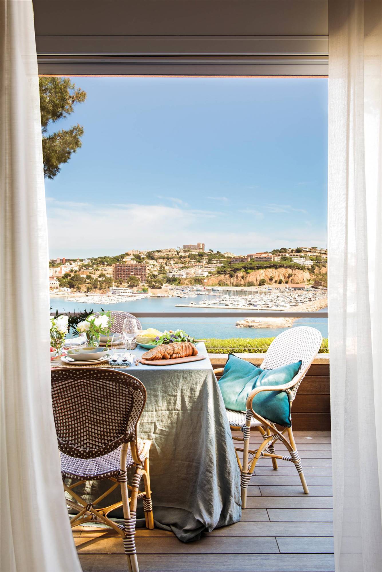 Comedor exterior con mantel azul y sillas tipo bistro que dan un aire clásico a la estancia. 