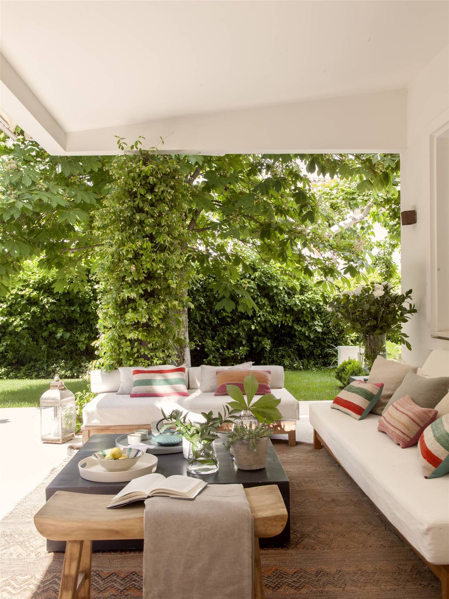 terraza-con-porche-con-vistas-al-jardin-y-sofas-blancos-00510160-O