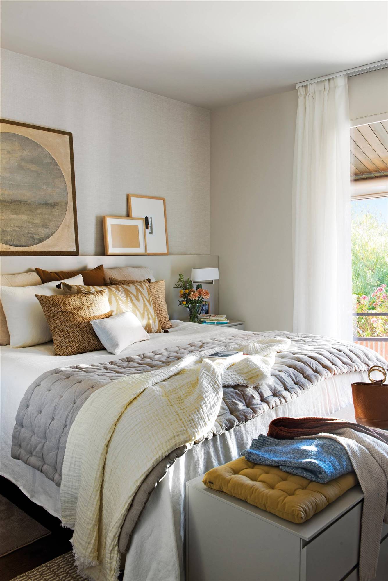 Dormitorio con cabecero de obra y ropa de cama de color gris, blanco y color arena. 