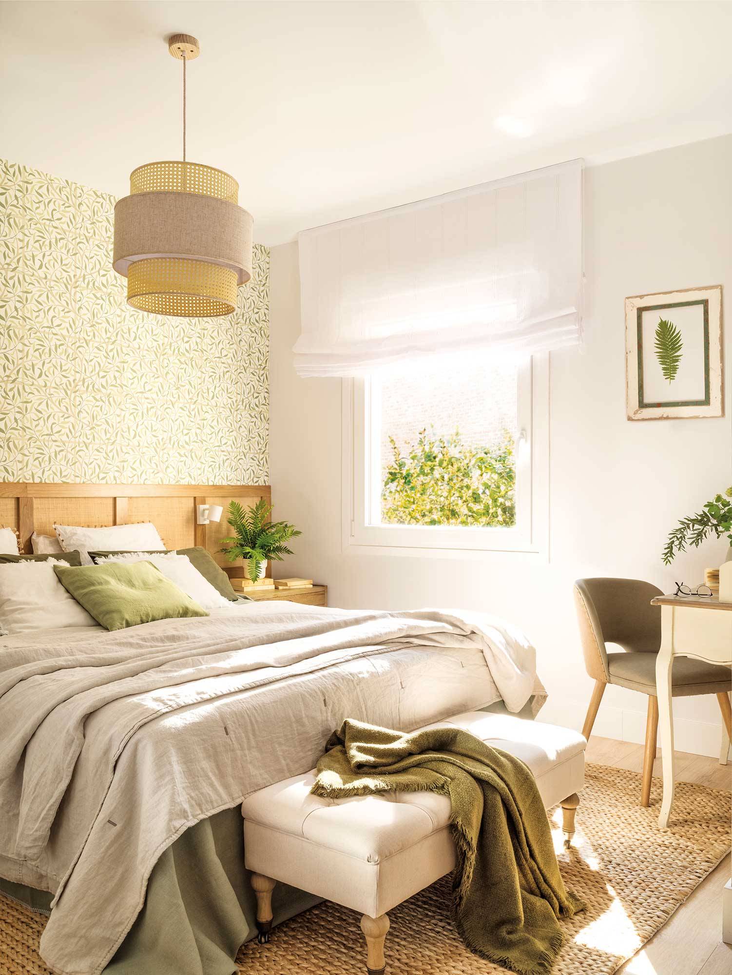Dormitorio con papel pintado vegetal, cabecero de madera de pared a pared y banco tapizado al pie de cama. 