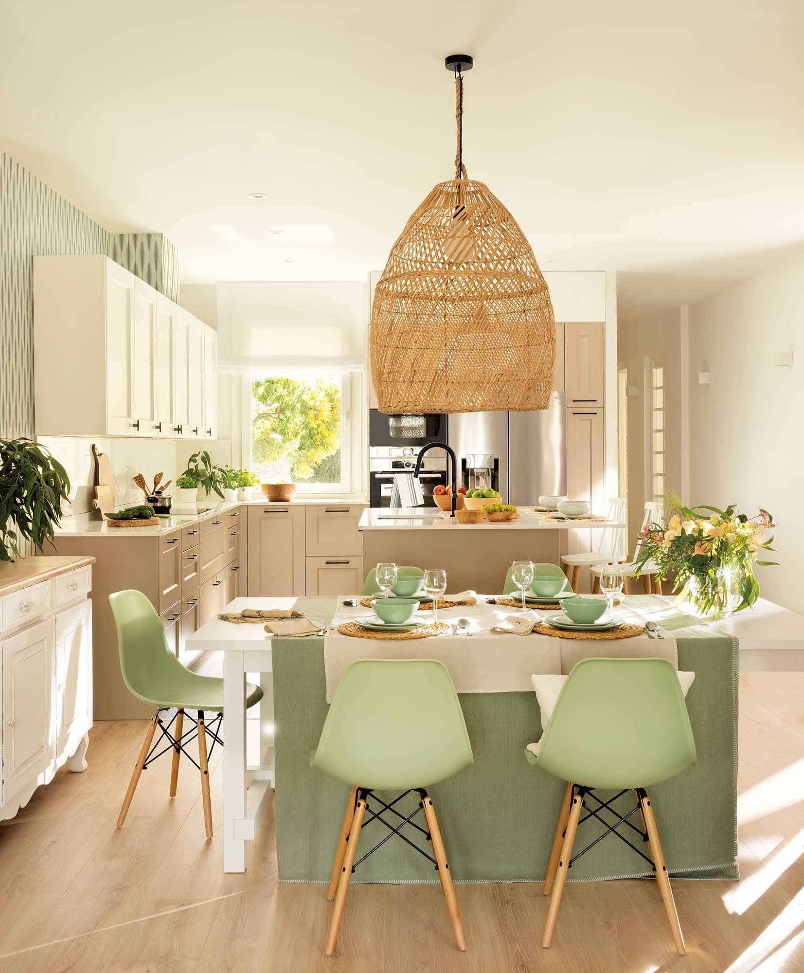 Comedor abierto a la cocina con sillas verdes de Vitra