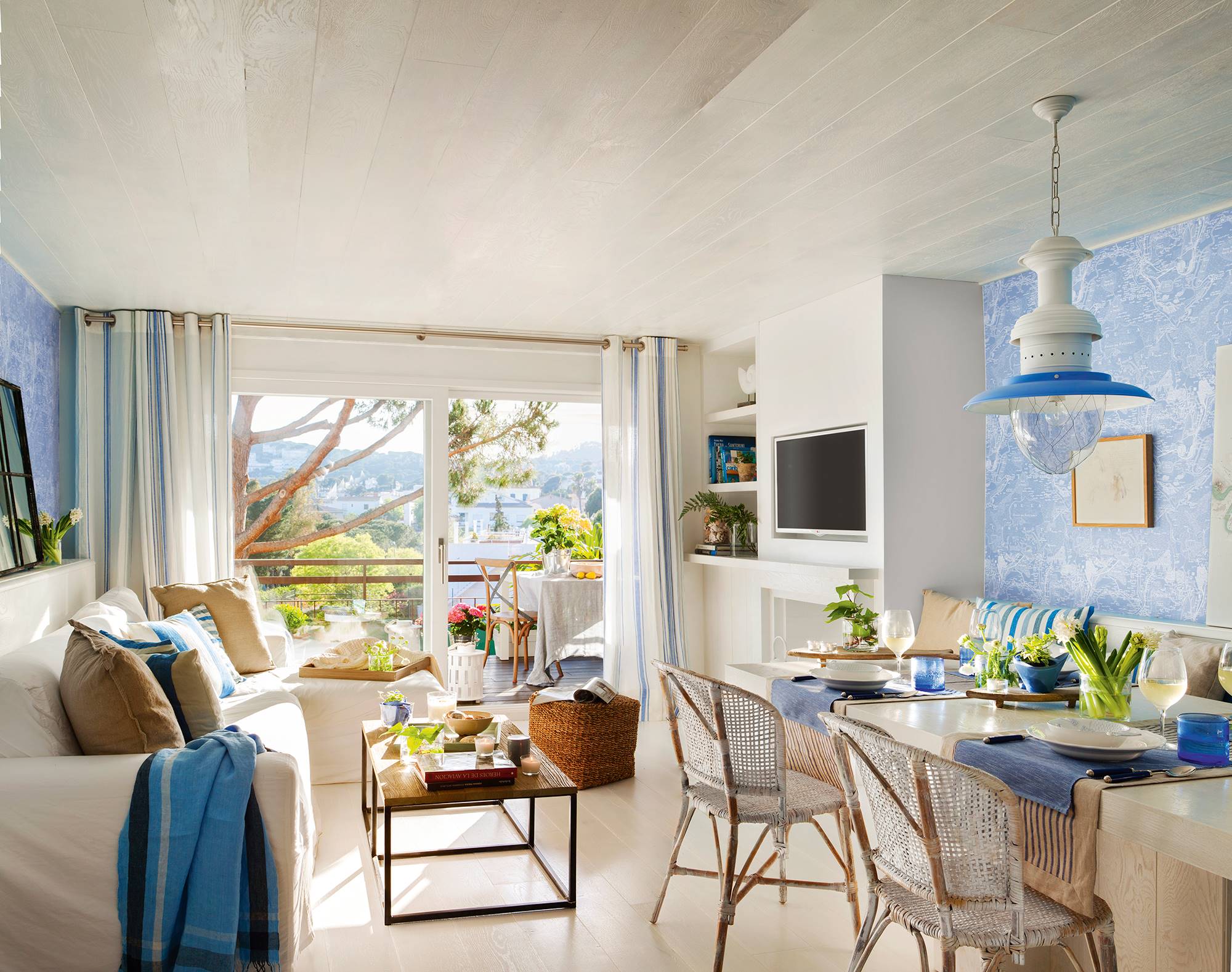 Salón con comedor con paredes azules y muebles blancos 00408090