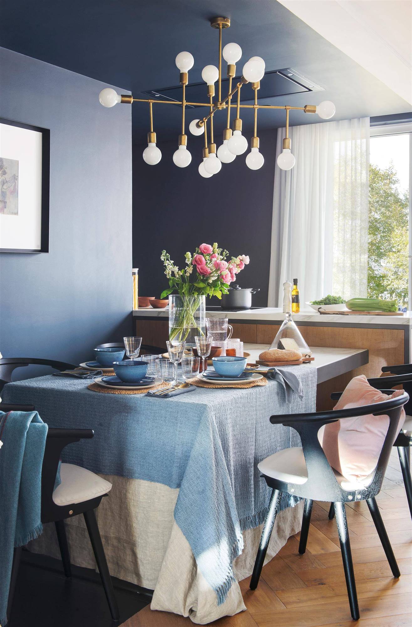 Comedor moderno con paredes azules y sillas negras. 