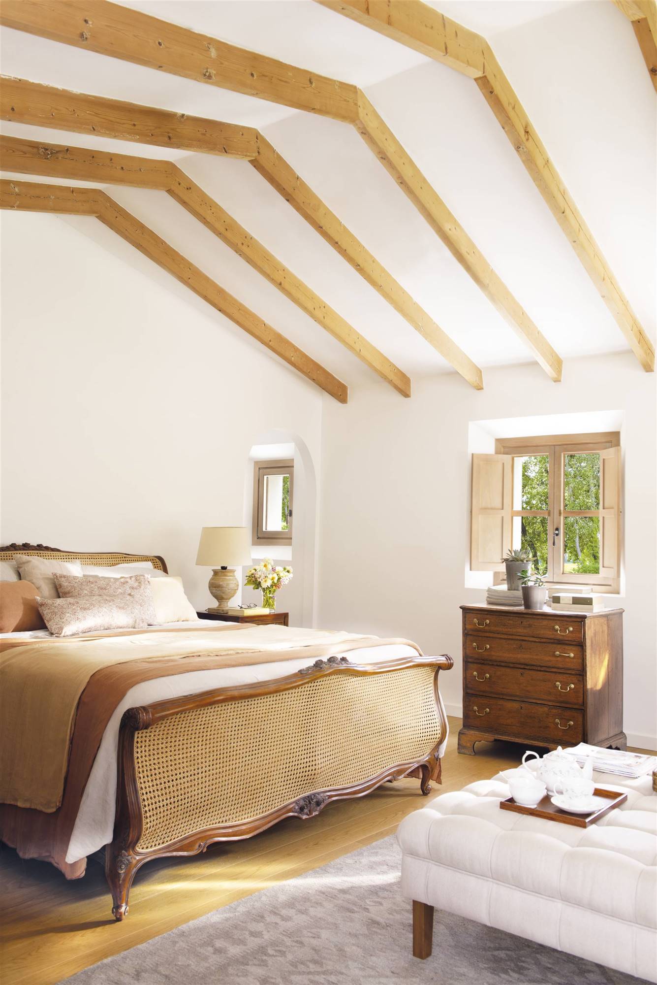 Dormitorio de verano de estilo clásico y con vigas de madera en tonos arena. 