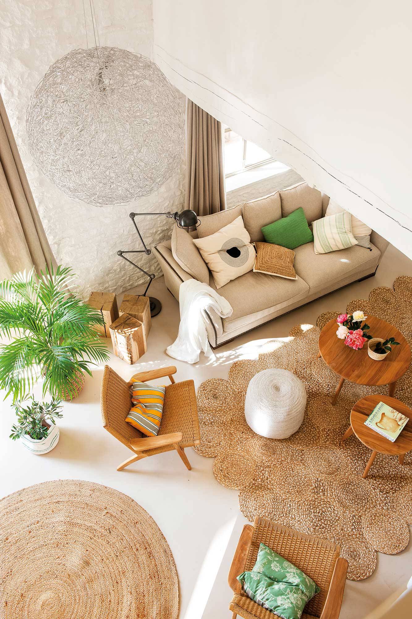 Salón con vista desde arriba con alfombras y muebles de fibras.