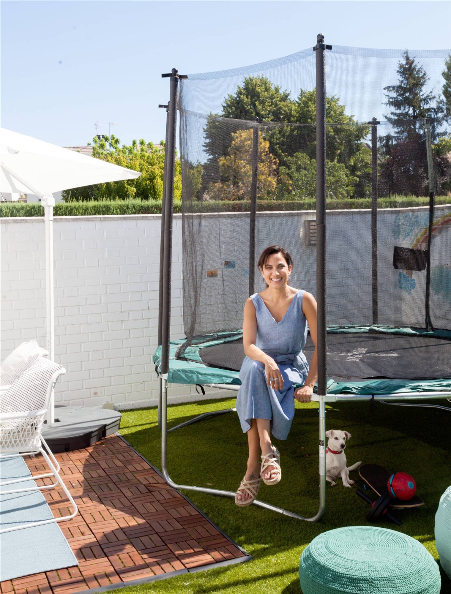 Terraza de Toni Acosta posando en la cama elástica de su hija junto a su perrita Amy.