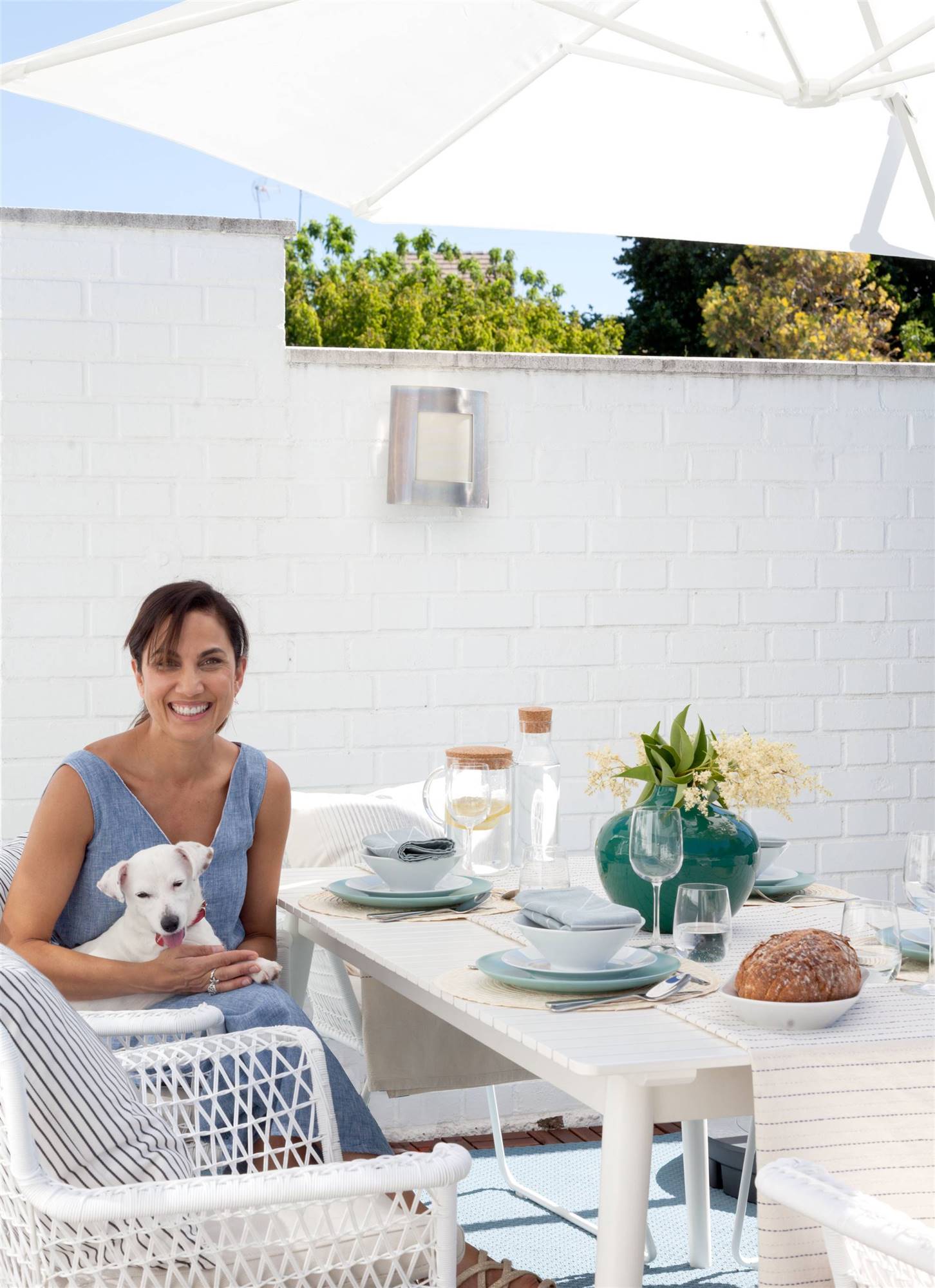 Comedor exterior de la terraza de Toni Acosta, que está posando junto a su perrita Amy.